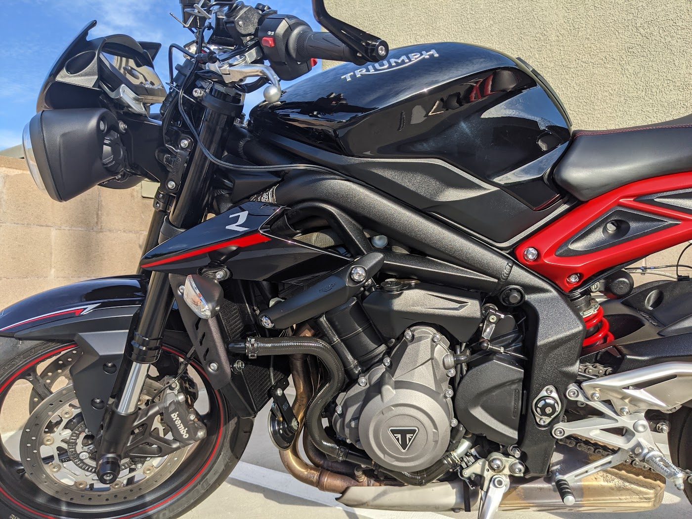 Glossy black tank on a Triumph Street Triple motorcycle after ceramic coating